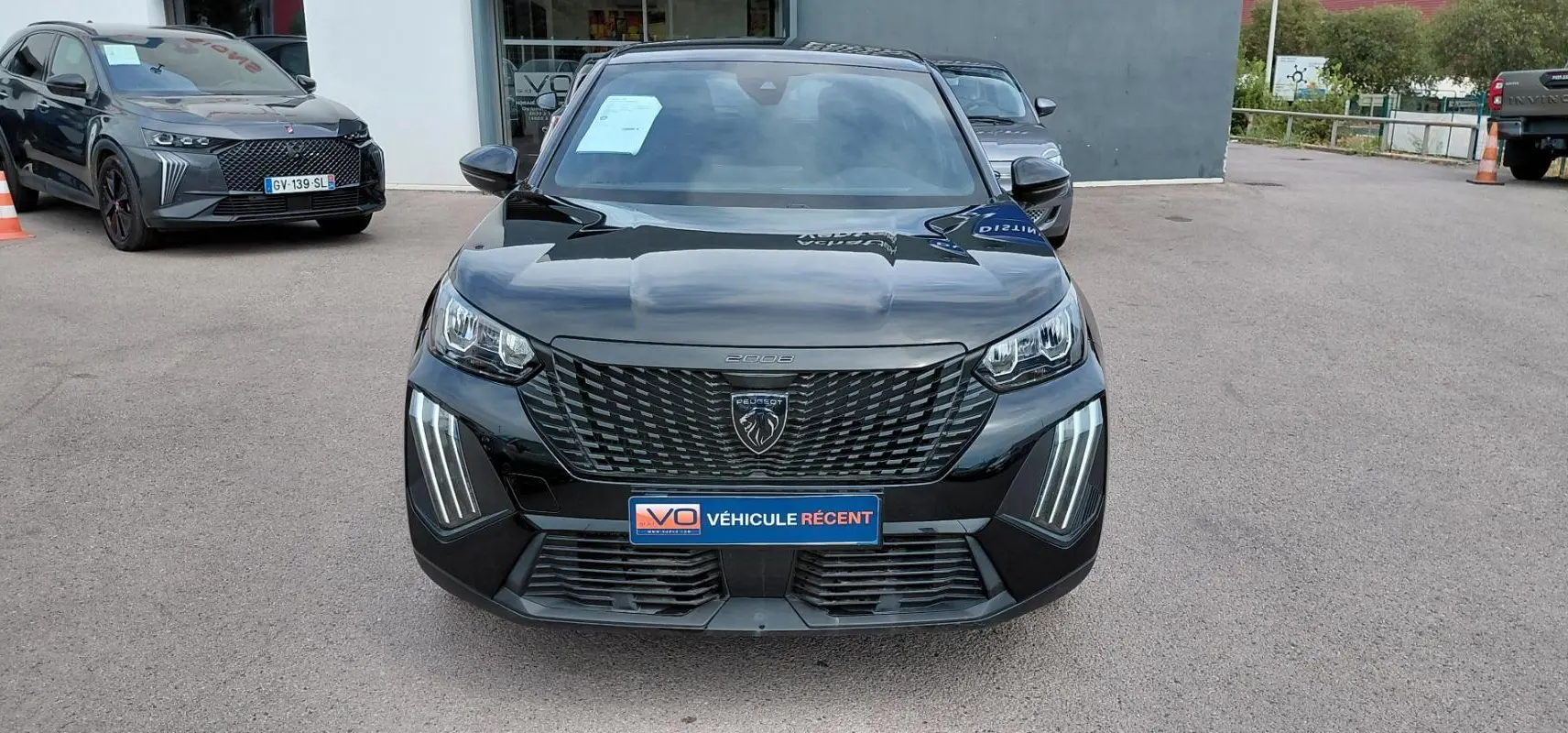 Vue de face du Peugeot 2008 Hybrid 145 e-DCS6 Style noir 2025 avec calandre distinctive et feux LED verticaux.