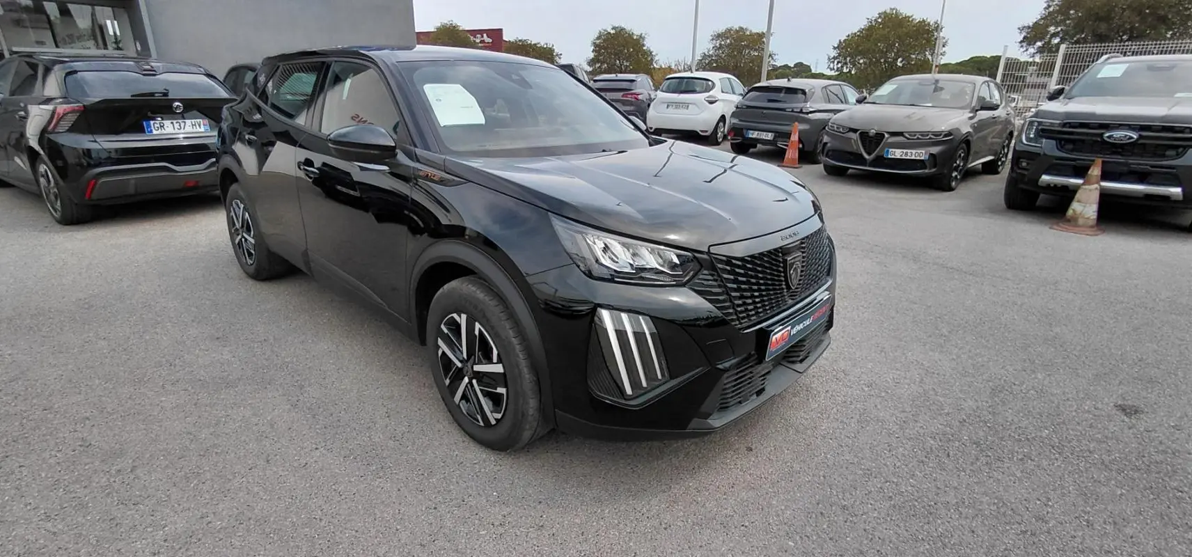 Peugeot 2008 Hybrid 145 e-DCS6 Style noir en 3/4 avant droit, avec calandre noire et feux LED distinctifs.