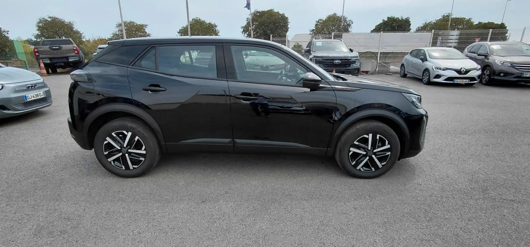 Peugeot 2008 Hybrid 145 e-DCS6 Style noir, vue de profil côté gauche, roues alliage et lignes modernes visibles.