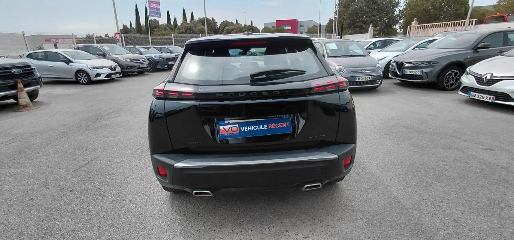 Vue arrière d’un Peugeot 2008 Hybrid 145 noir 2025 avec feux LED caractéristiques et double sortie d’échappement.