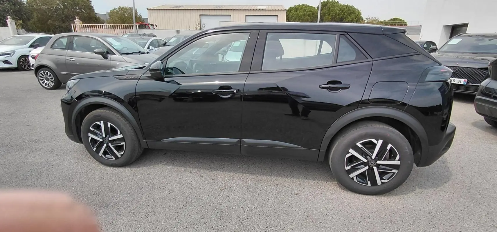 Peugeot 2008 Hybrid 145 e-DCS6 Style noir vue de profil côté gauche, avec jantes alliage distinctives.