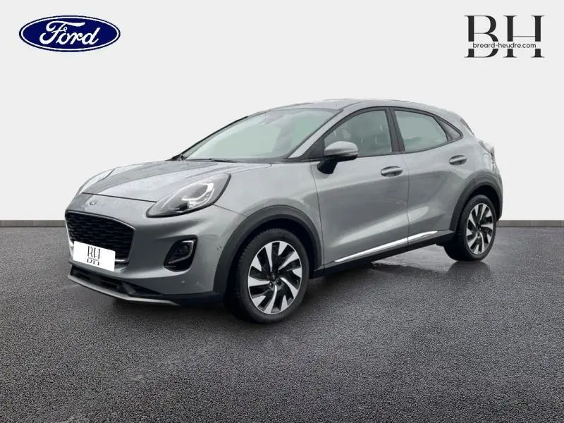 Ford Puma 2023 gris Solar métallisé en vue 3/4 avant droit, avec jantes alliage et lignes dynamiques visibles.