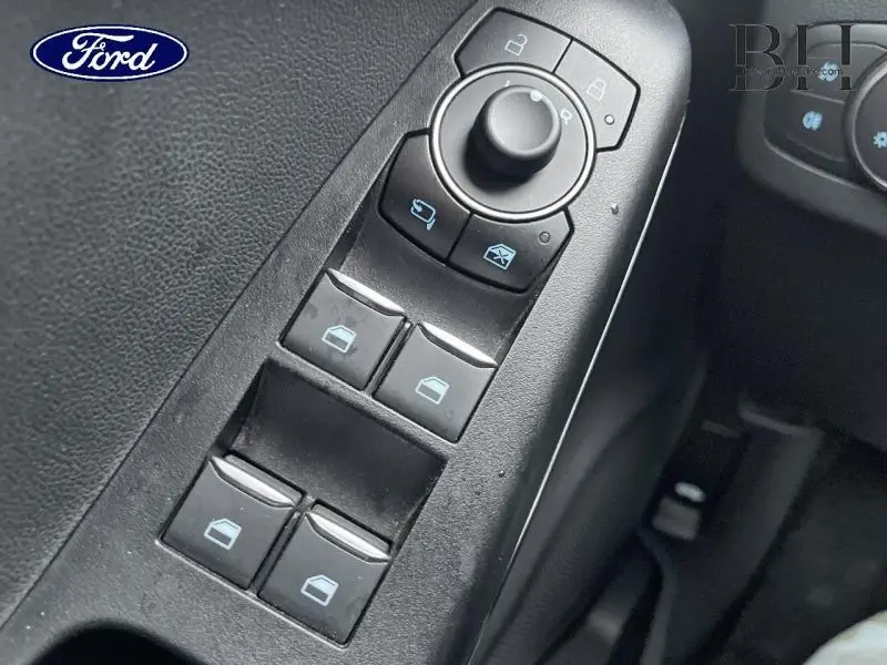 Gros plan sur les commandes des vitres électriques et rétroviseurs intérieurs d’un Ford Puma 2023, intérieur noir.