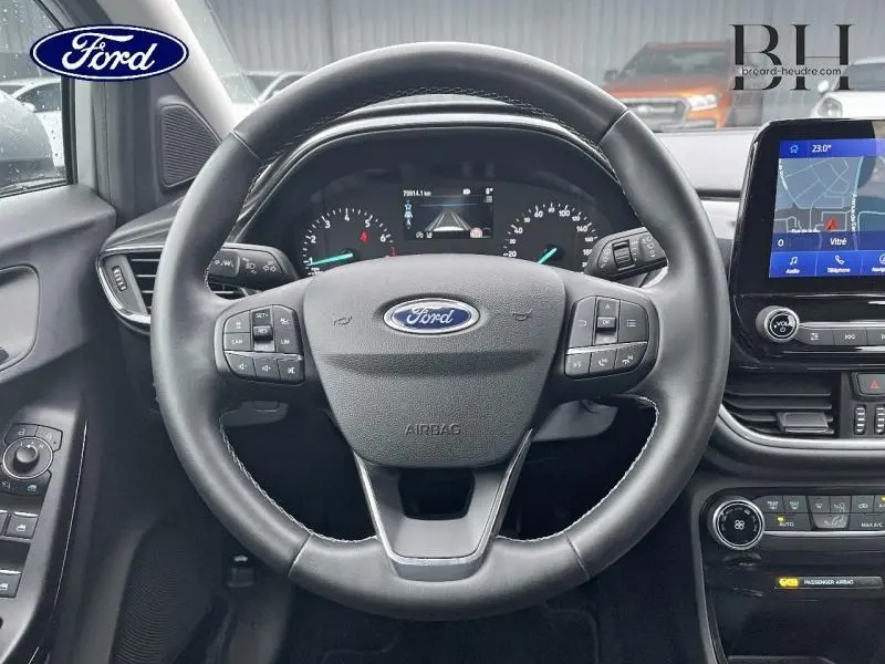 Vue intérieure centrée sur le volant noir du Ford Puma 2023, avec tableau de bord et écran tactile visible à droite.