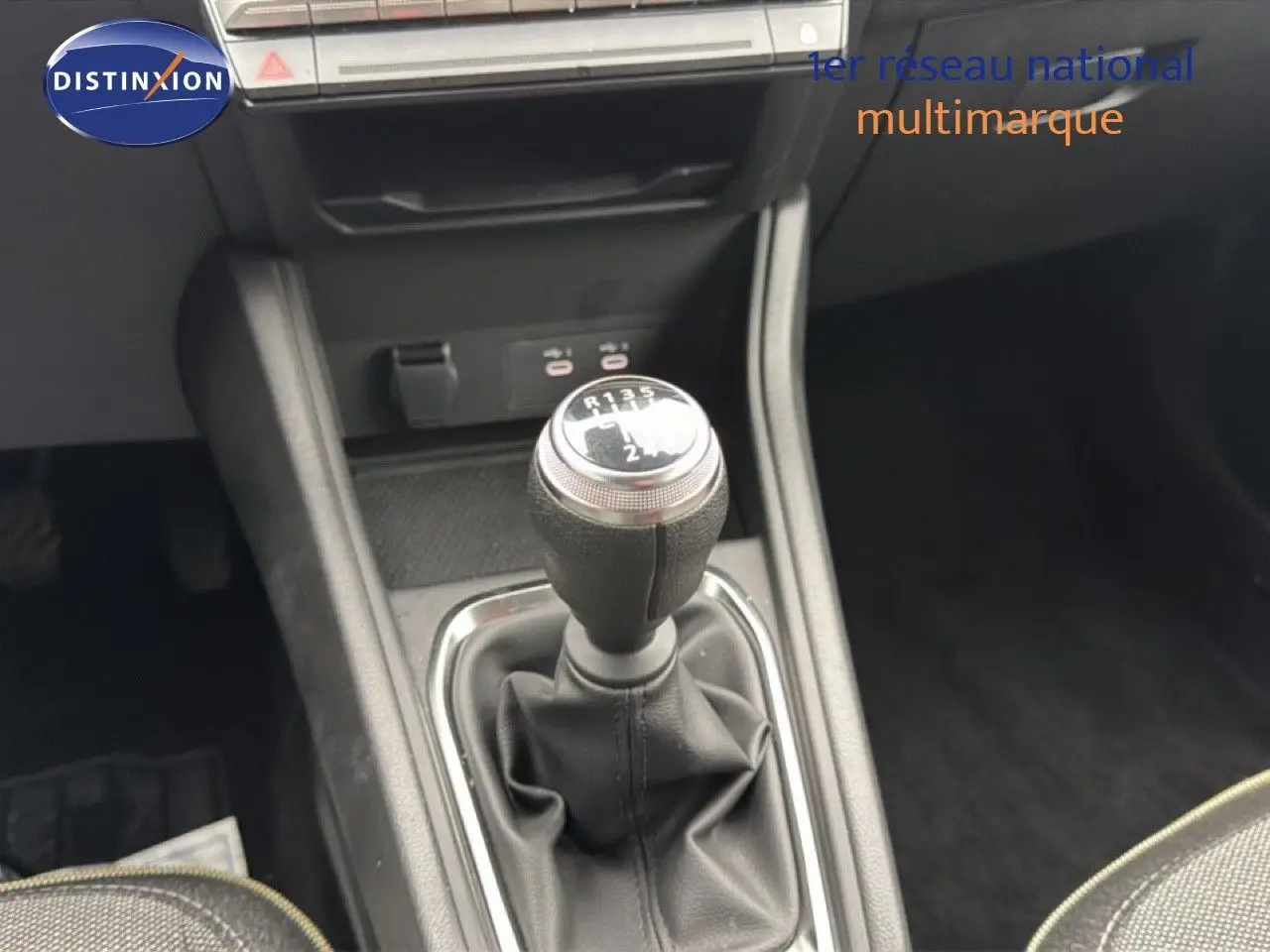 Le véhicule Renault Captur 1.0 ECO-G 100CH TECHNO bleu Iron Metal est visible en intérieur, avec un levier de vitesse manuel en gros plan.