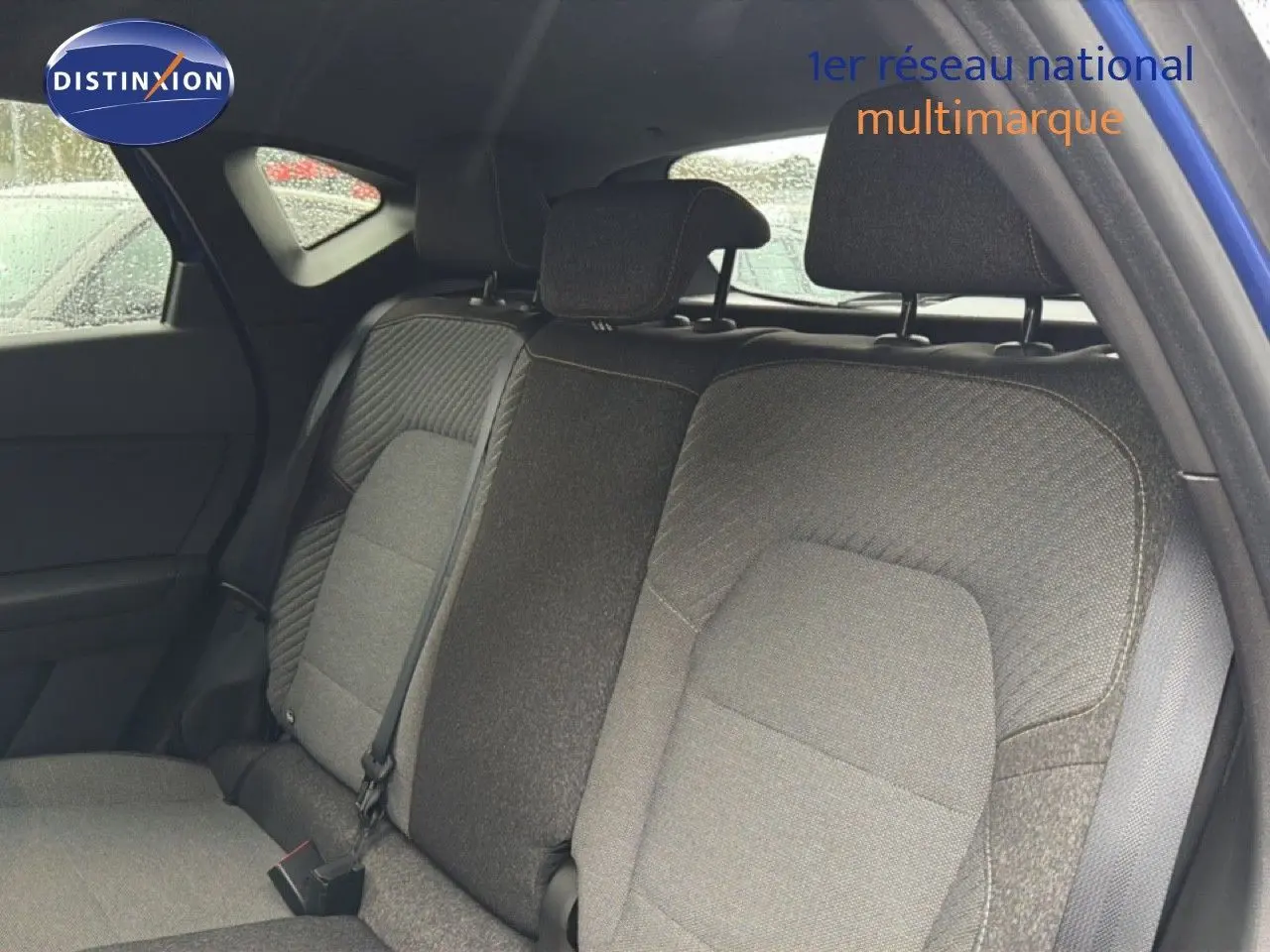 Vue intérieure arrière du Renault Captur 2025 bleu Iron Metal, montrant les sièges arrière en tissu noir et gris.