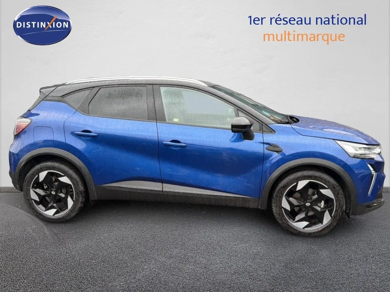 Renault Captur bleu Iron Metal en profil côté gauche, avec toit noir et jantes bicolores distinctives.