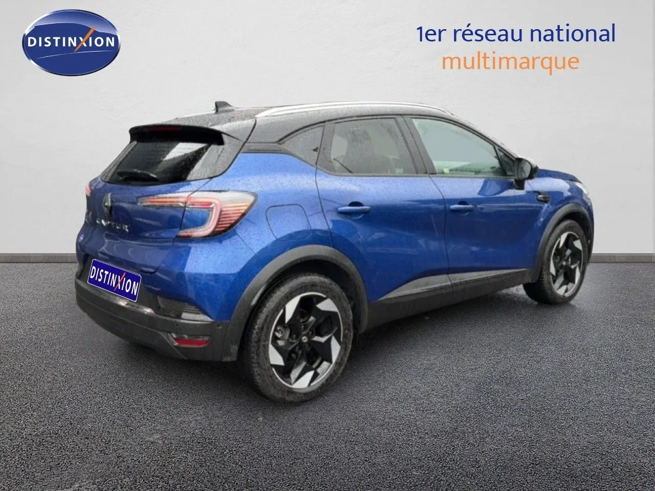 Vue 3/4 arrière droite d'un Renault Captur bleu Iron Metal avec toit noir et jantes bi-ton.