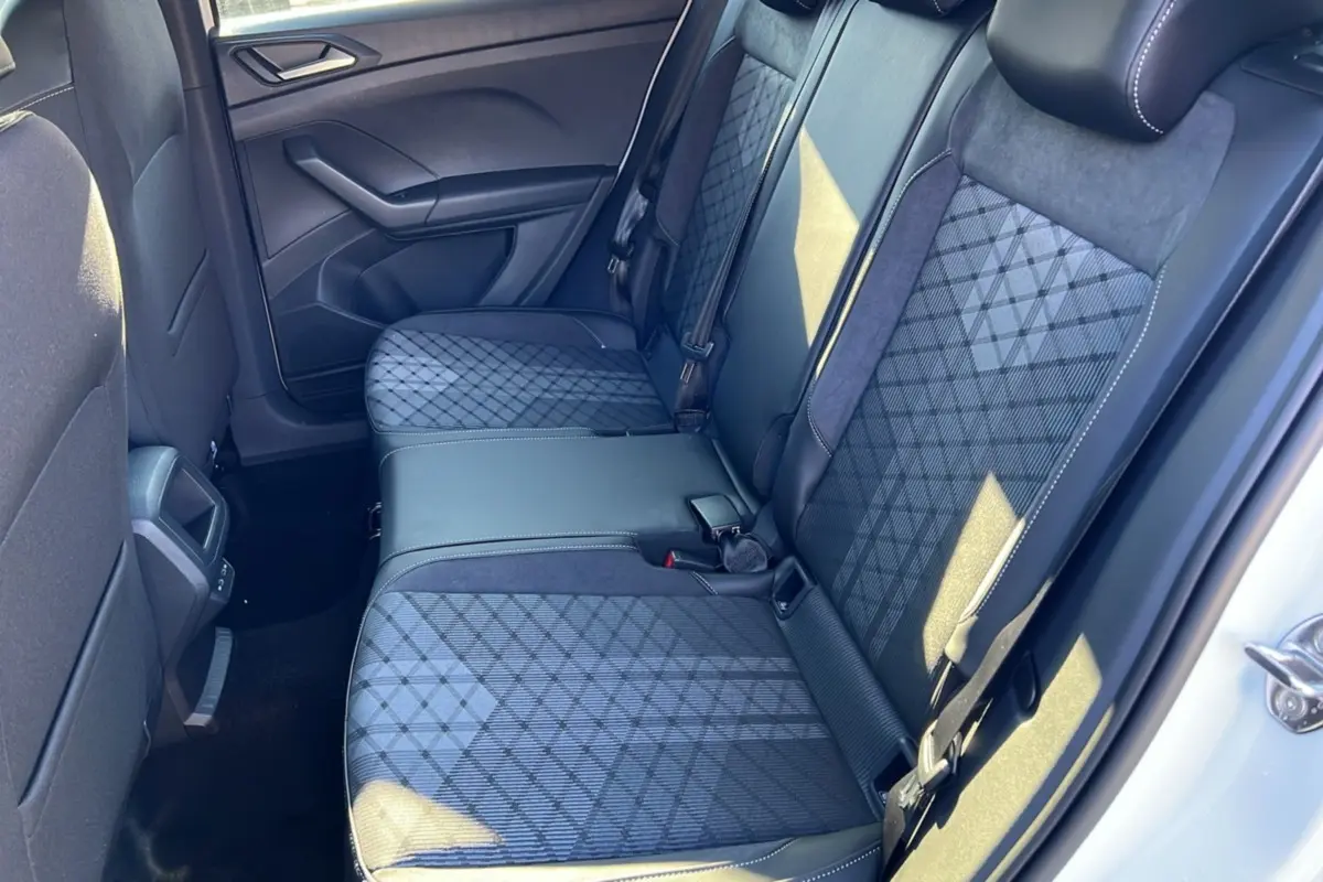 Vue intérieure côté droit sur la banquette arrière tissu gris foncé à motifs géométriques du Volkswagen T-Cross blanc pur 2025.