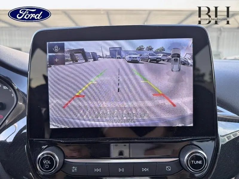 Écran central de la Ford Puma 2024 montrant la caméra de recul avec lignes de guidage, intérieur noir visible.