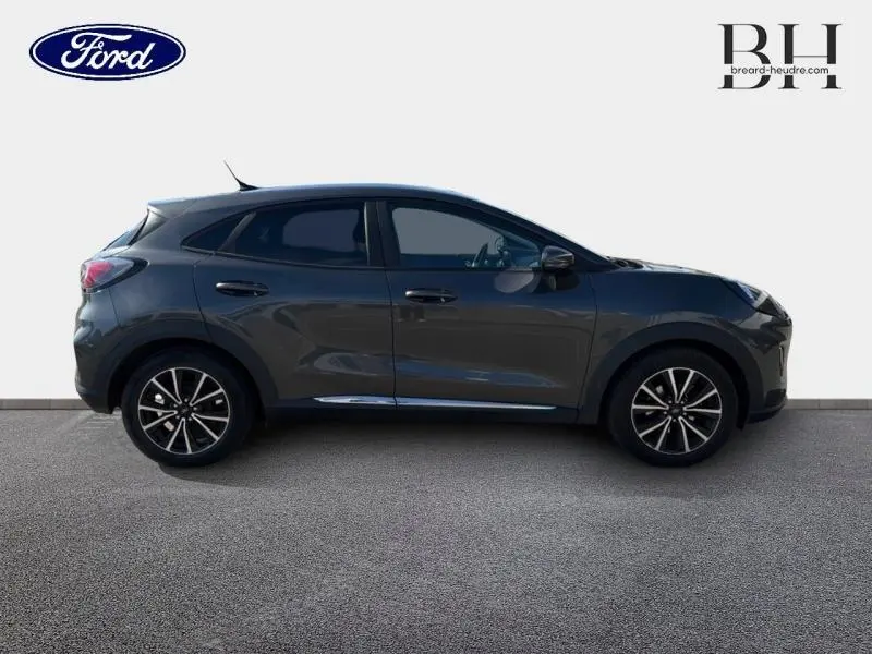 Vue de profil droit d'un Ford Puma 2024 gris métallisé avec jantes noires et vitres arrière surteintées.