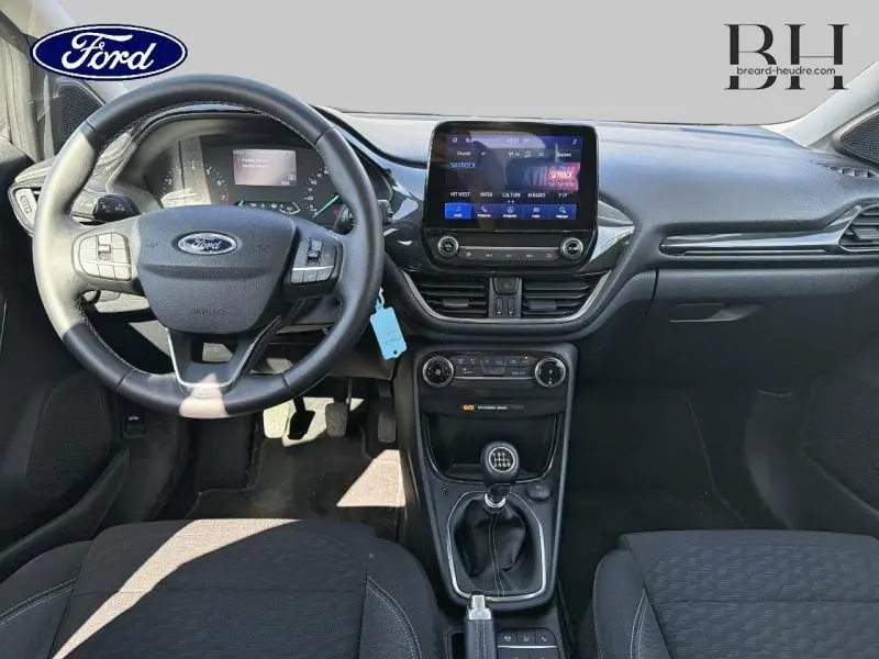 Vue intérieure avant de la Ford Puma 2024 avec tableau de bord noir, volant multifonction et écran tactile central.