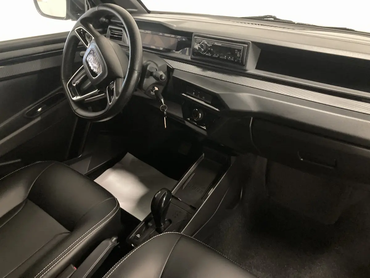 Vue intérieure côté conducteur du tableau de bord et console centrale noire du Ligier JS50 0.5 REVO D+ SELECT avec autoradio Pioneer.