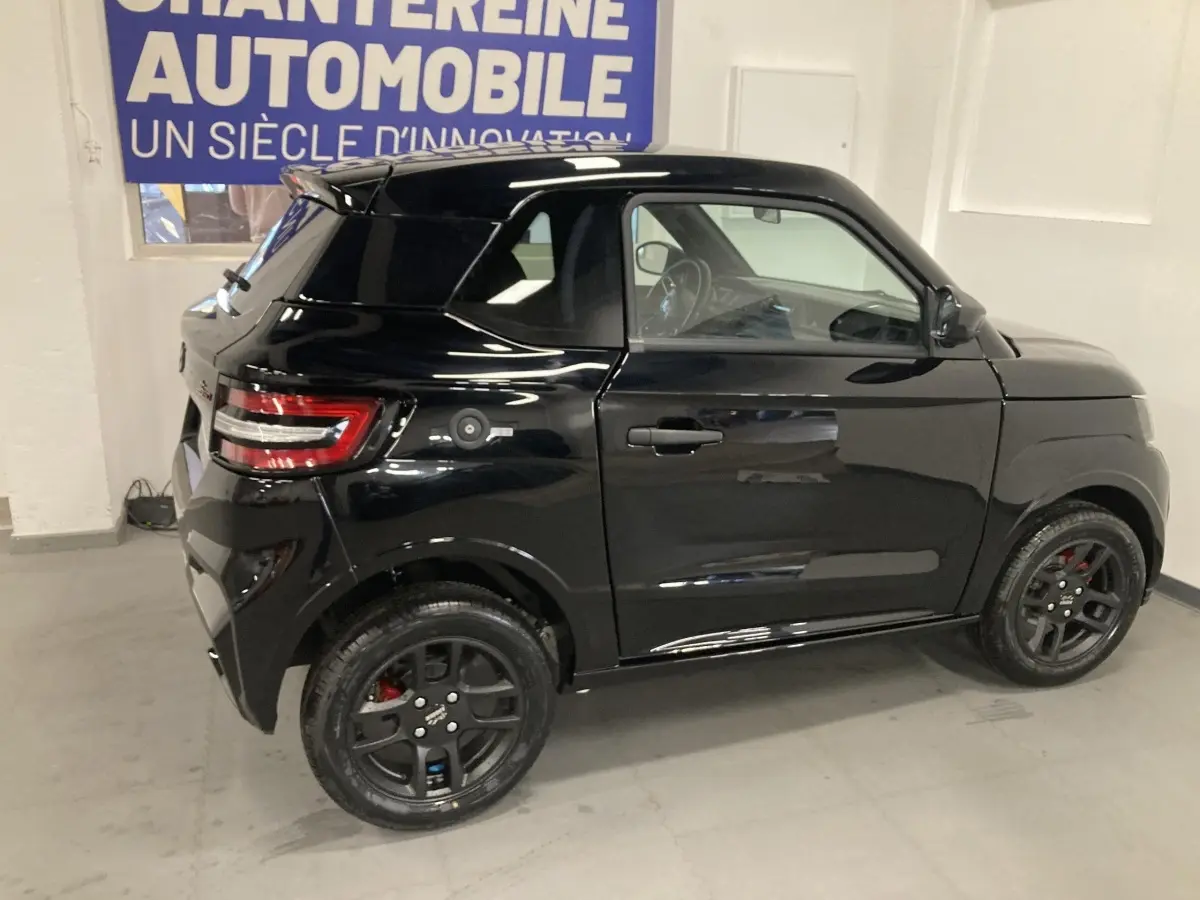 Vue de profil droit d'une LIGIER JS50 0.5 REVO D+ SELECT noire avec jantes alu noires et feux arrière LED en intérieur.