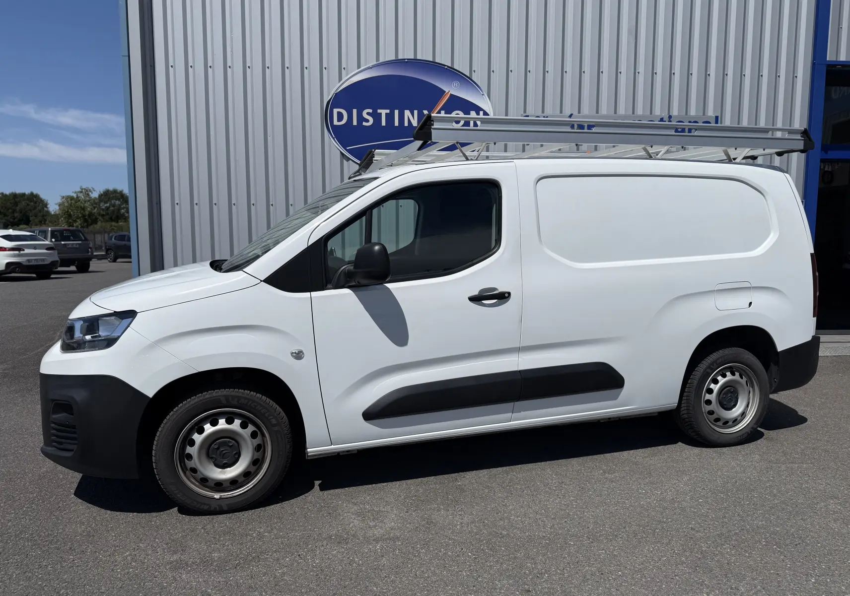 Vue de profil côté gauche d’un utilitaire Citroën Berlingo XL blanc banquise avec galerie de toit en aluminium.