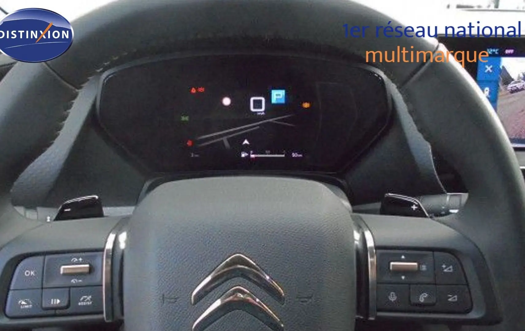 Vue rapprochée du volant cuir noir et du tableau de bord numérique d'une Citroën C5 X 2023.