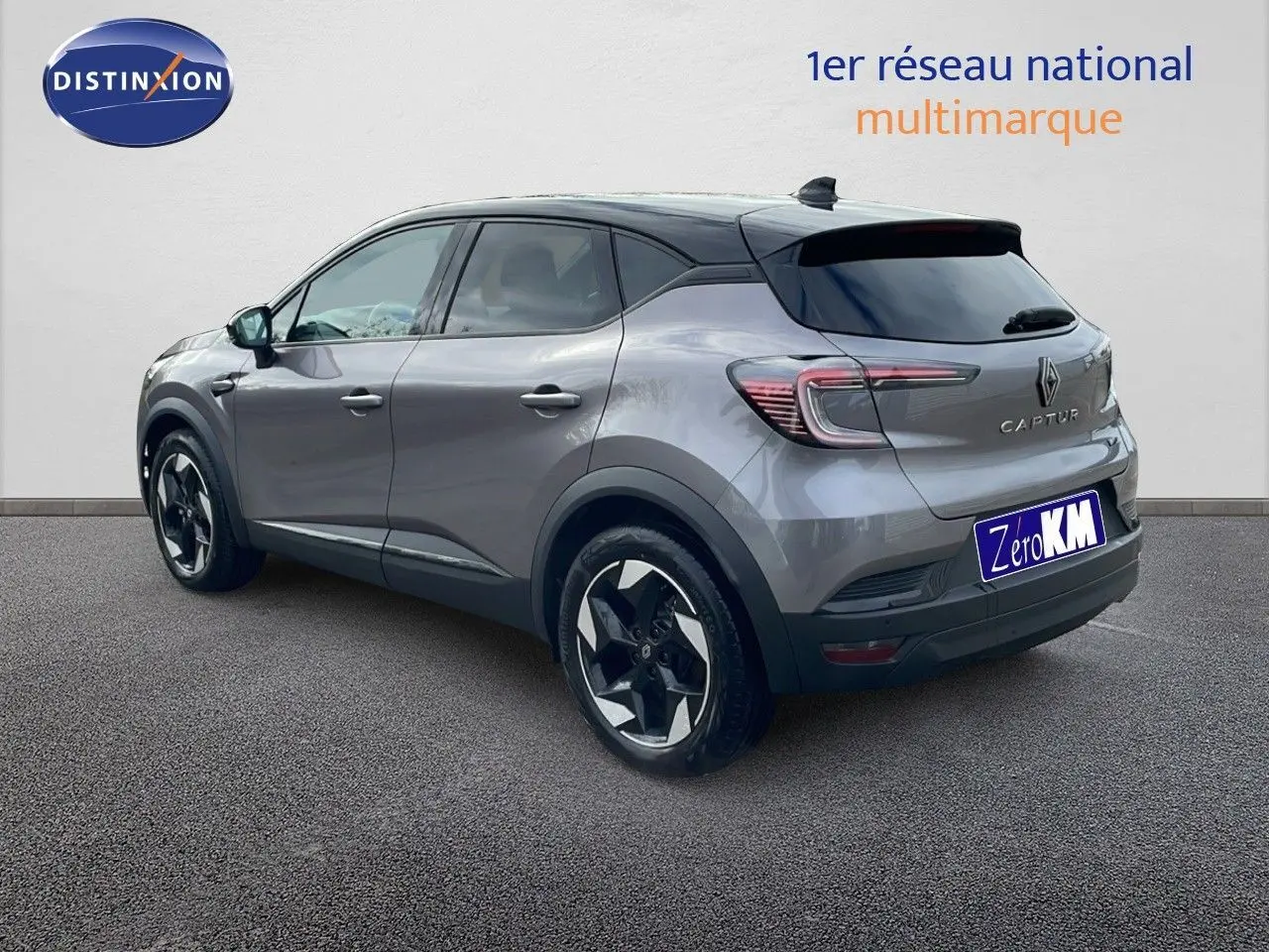 Renault Captur E-Tech gris Cassiopée métal avec toit noir, vue 3/4 arrière côté gauche, jantes biton distinctives.