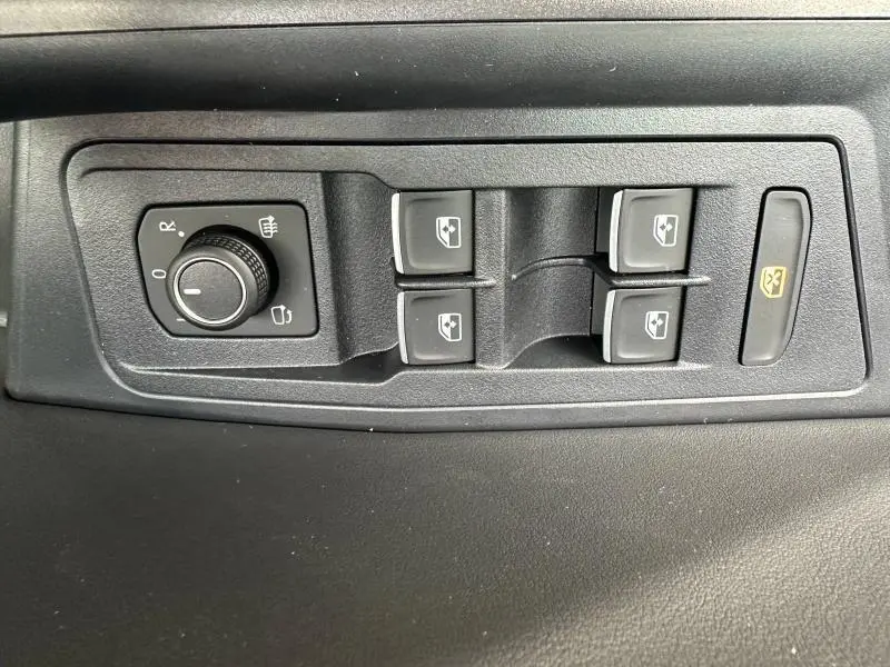 Panneau de commandes des vitres et réglage des rétroviseurs côté conducteur du Volkswagen T-Roc noir Grenadilla 2025.