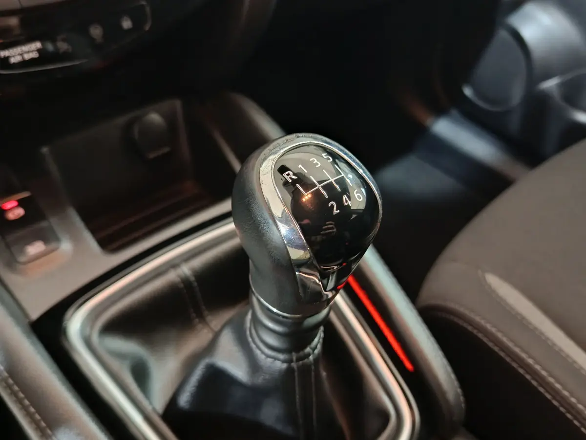 Le levier de vitesses manuel noir avec chrome du Nissan Qashqai 1.5 DCI 115 Business Edition, vue rapprochée intérieure.