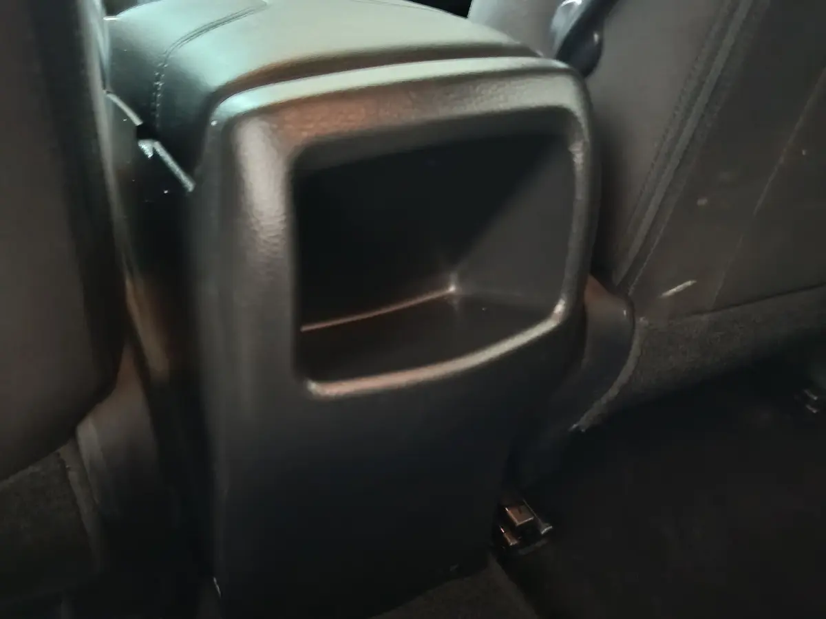 Rangement central arrière en plastique noir entre les sièges arrière du Nissan Qashqai 1.5 DCI gris clair de 2019.