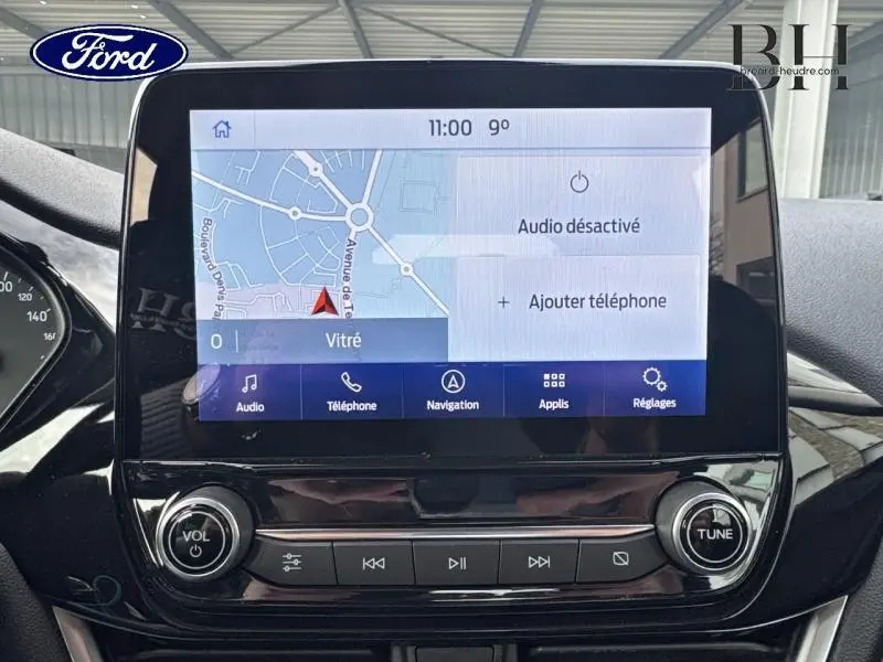 Écran tactile central de la Ford Fiesta 2021 affichant la navigation et les commandes multimédia, intérieur noir.