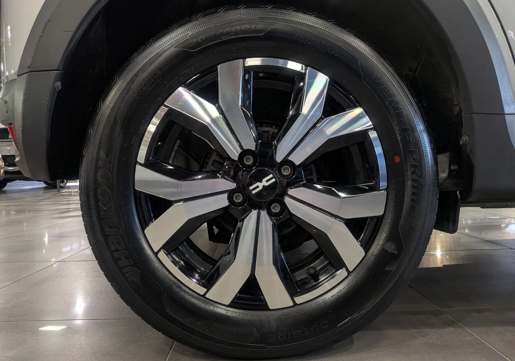 Gros plan sur la roue avant droite du Dacia Sandero Stepway 2023 gris Moonstone avec jante alliage bicolore.