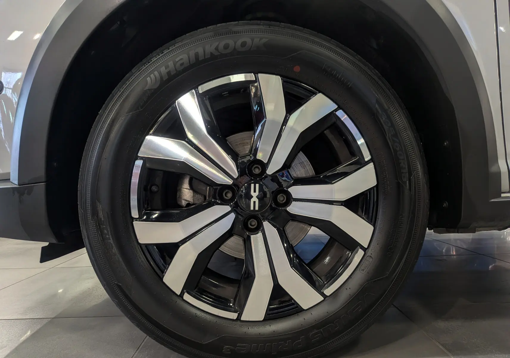 Gros plan sur la roue avant droite d'une Dacia Sandero Stepway gris Moonstone avec jante alliage bicolore brillante.