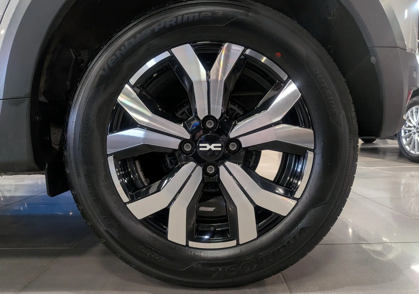 Gros plan sur la jante bi-ton noire et argentée du Dacia Sandero Stepway gris Moonstone, roue avant droite.