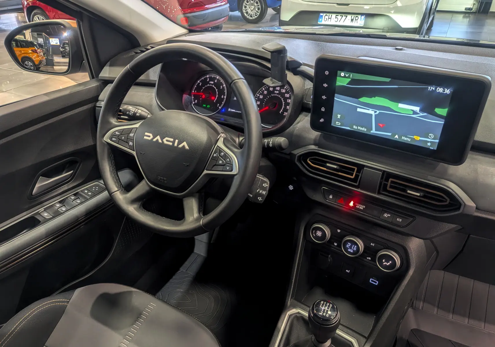 Vue intérieure du poste de conduite de la Dacia Sandero Stepway 2023, avec volant, tableau de bord et écran tactile central.