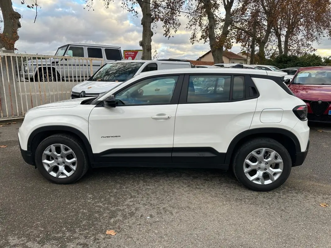 Vue de profil côté gauche d'un Jeep Avenger blanc 2024 avec jantes alliage 17 pouces et poignées de porte ton carrosserie.