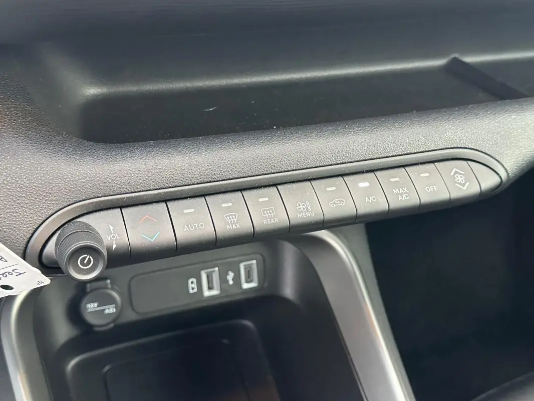 Gros plan sur la console centrale noire du Jeep Avenger 2024, montrant les commandes climatisation et prises USB.