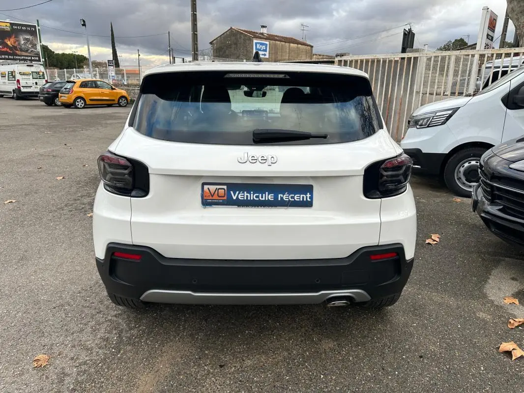 Vue arrière d'un Jeep Avenger blanc 2024 avec feux arrière fumés et pare-chocs noir contrastant.