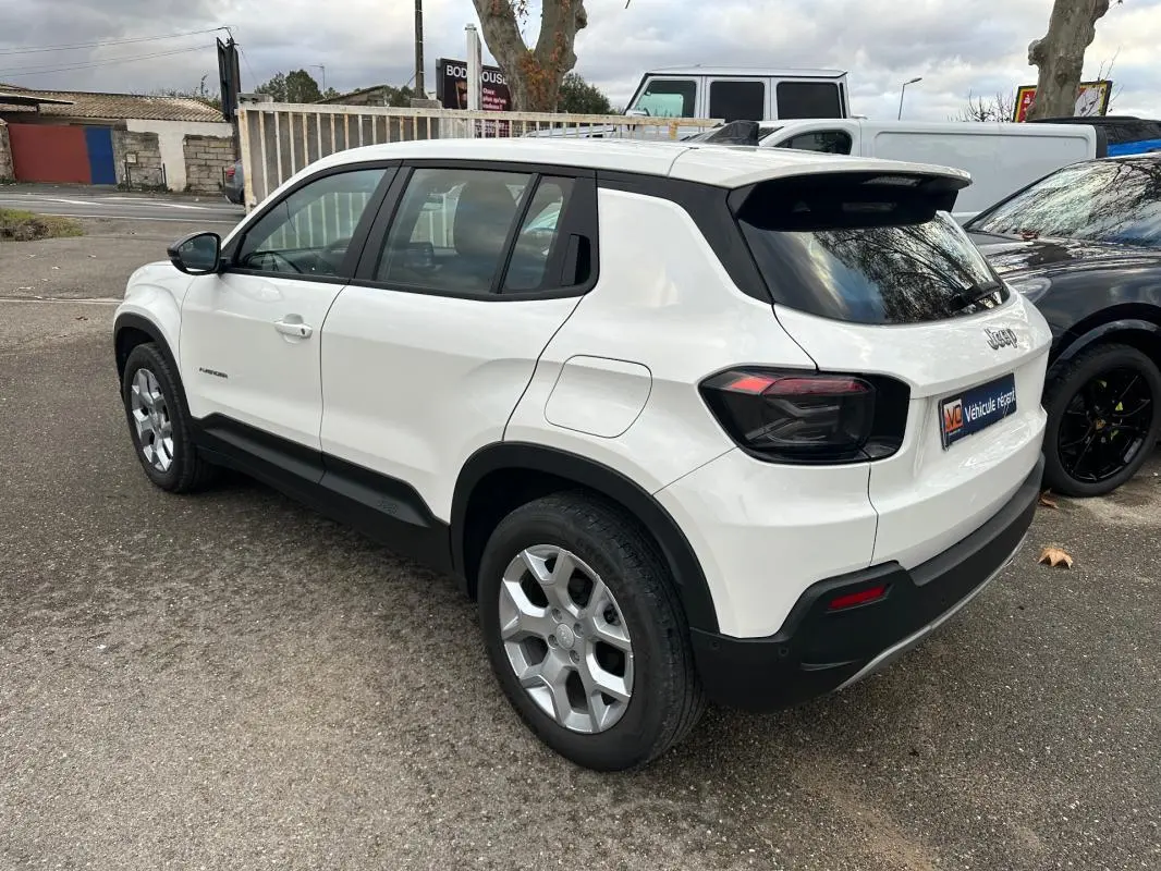 Jeep Avenger blanc vu en 3/4 arrière droit, avec jantes alliage 17 pouces et vitres teintées.