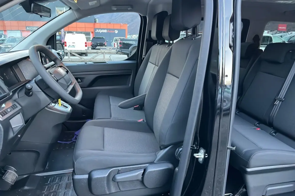 Vue intérieure côté gauche du FIAT Scudo Fourgon noir 2025, montrant les sièges avant et arrière en tissu gris.