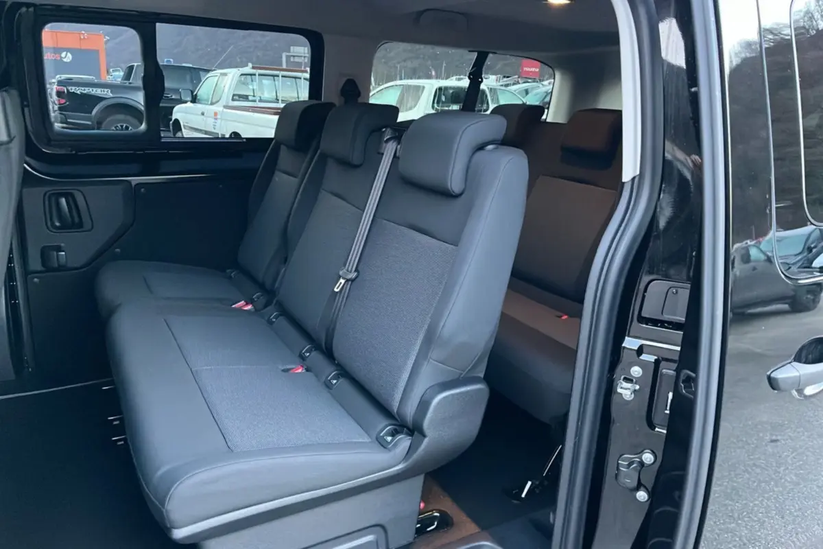 Vue intérieure côté droit du FIAT Scudo Fourgon noir 2025, montrant la banquette arrière 3 places et la porte latérale coulissante ouverte.