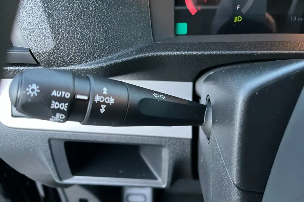 Gros plan sur la manette des feux et clignotants du tableau de bord du Fiat Scudo Fourgon noir, version 2025.