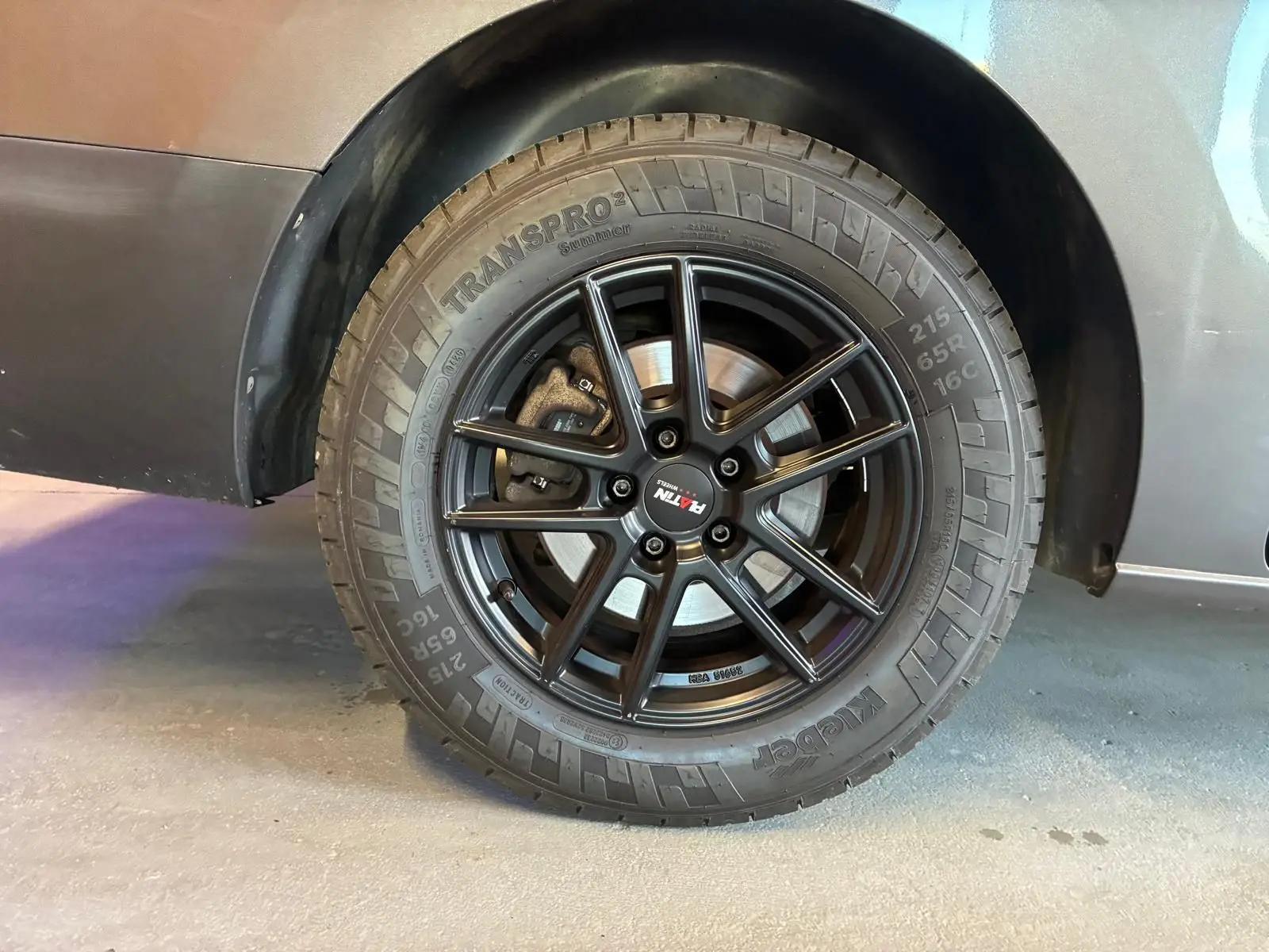 Gros plan sur la roue arrière droite du Citroën Jumpy gris, mettant en valeur la jante noire à multiples branches.