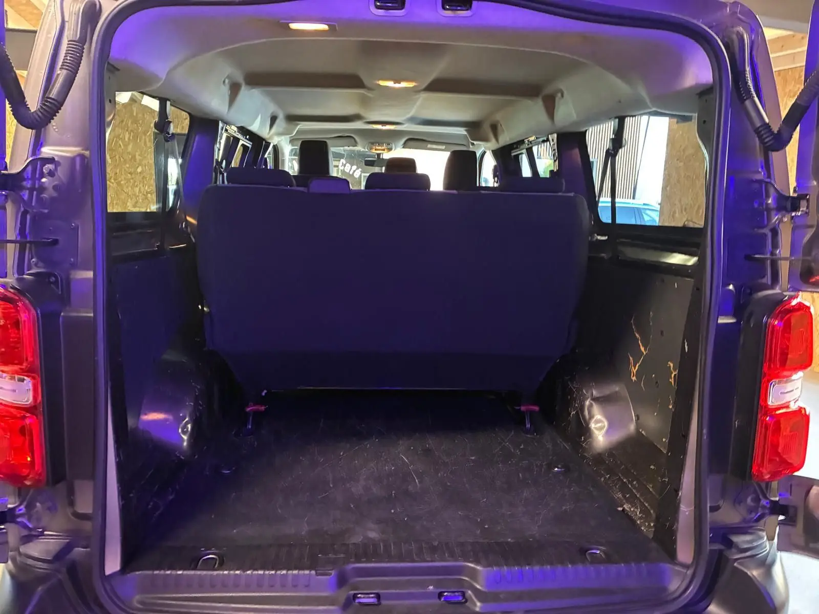 Vue arrière ouverte du Citroën Jumpy XL Spacetourer gris, montrant l'espace de chargement et les sièges arrière.