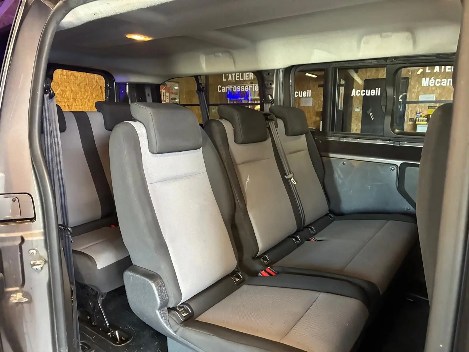Vue intérieure côté gauche montrant les sièges tissu gris et noir du Citroën Jumpy XL Spacetourer 9 places.