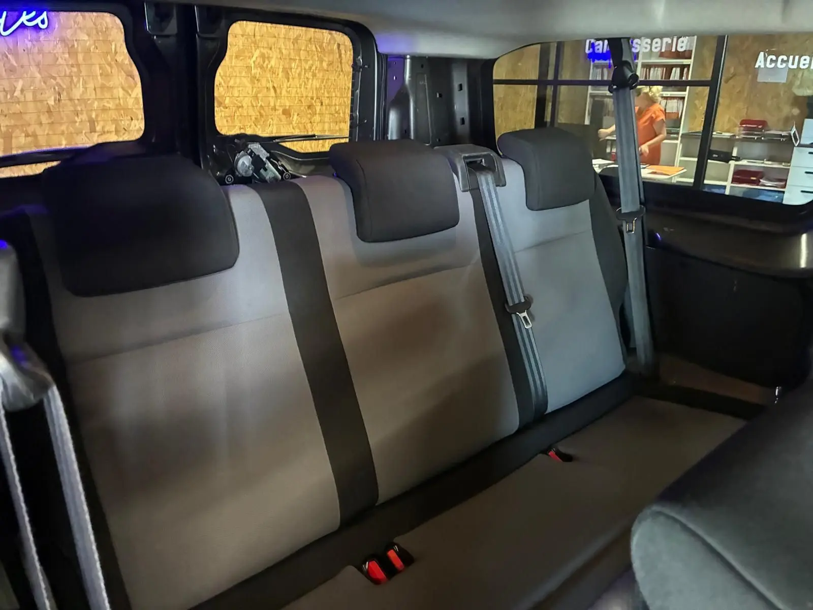 Vue intérieure arrière du Citroën Jumpy XL Spacetourer 2017, montrant les sièges tissu gris à trois places avec ceintures de sécurité.