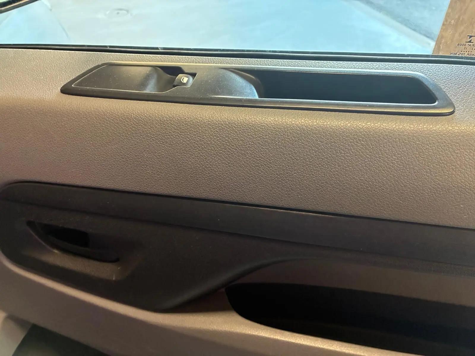 Gros plan sur la porte intérieure côté gauche du Citroën Jumpy XL Spacetourer gris, avec poignée et commande de fenêtre.