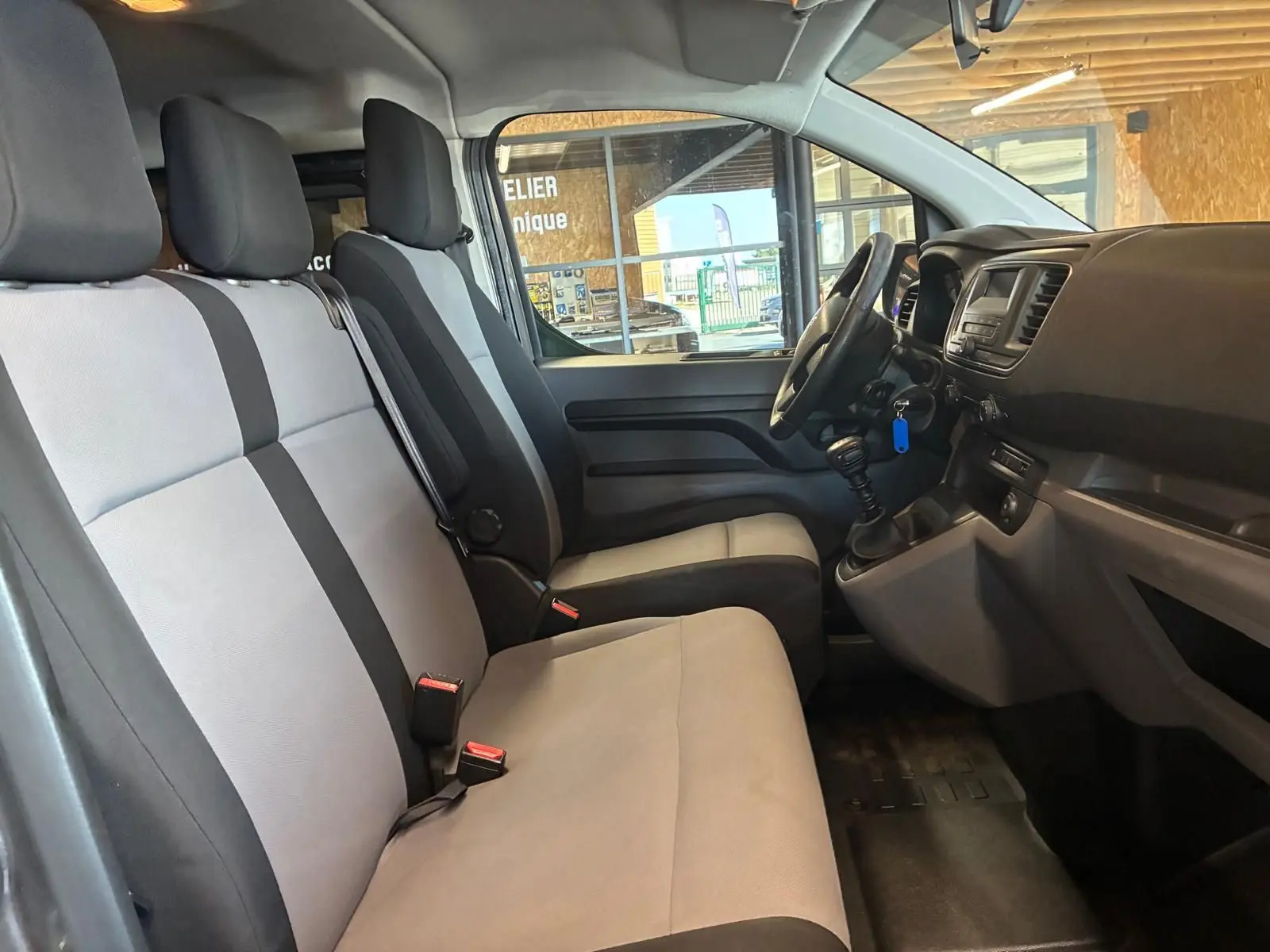 Vue intérieure côté conducteur du Citroën Jumpy XL Spacetourer 2017, sièges tissu gris clair et tableau de bord noir.