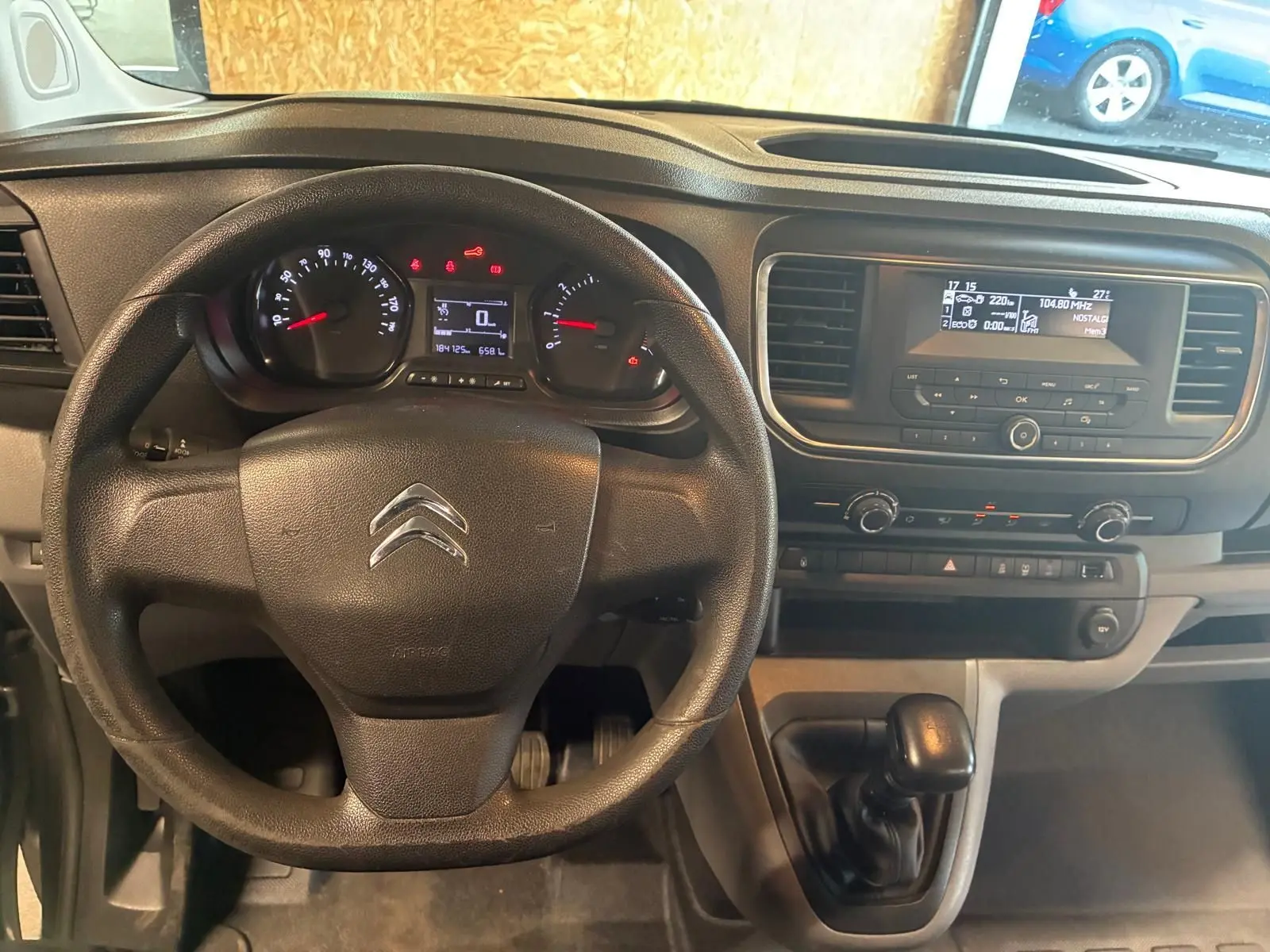 Vue intérieure centrée sur le volant noir et le tableau de bord du Citroën Jumpy XL Spacetourer gris de 2017 avec boîte manuelle.