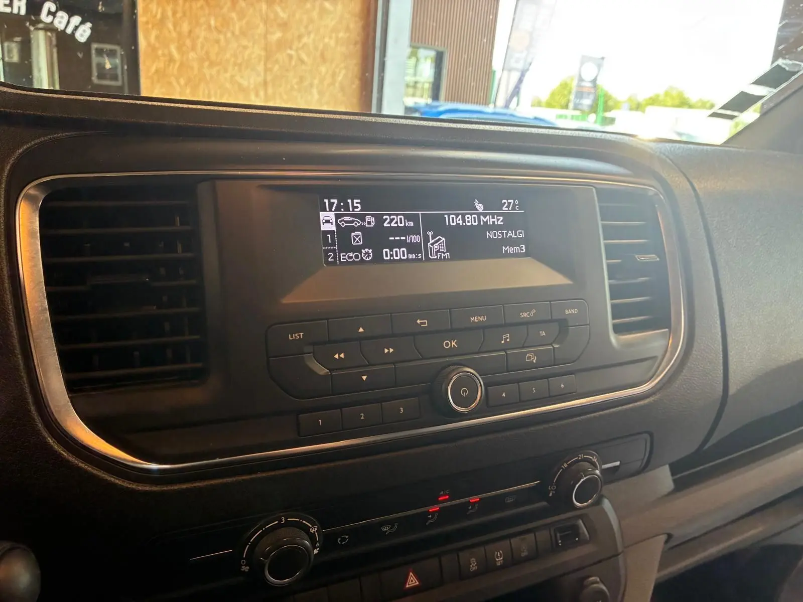 Vue rapprochée du tableau de bord du Citroën Jumpy gris, mettant en valeur l’écran central et les commandes radio.