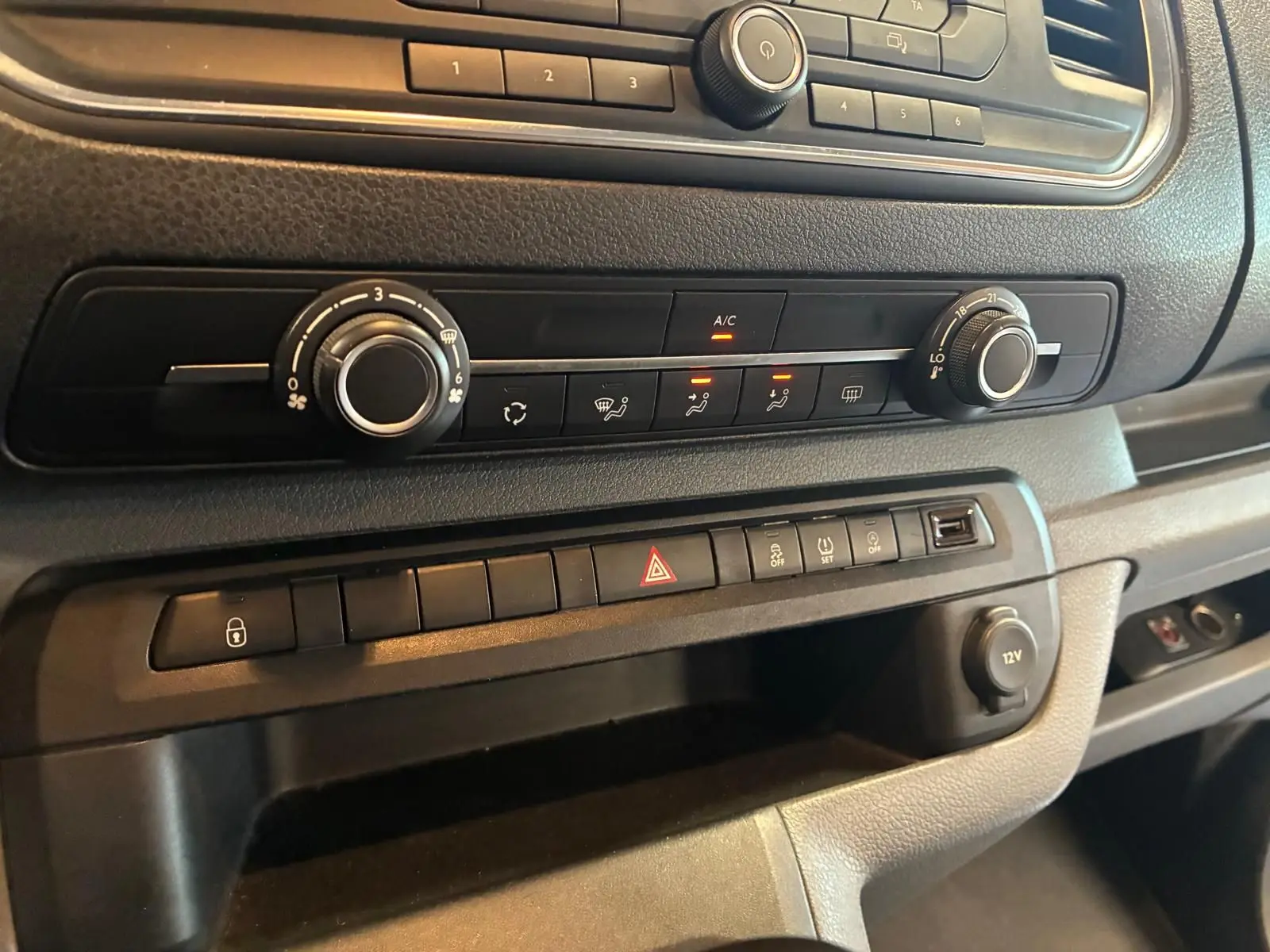 Détail du tableau de bord du Citroën Jumpy XL Spacetourer 2017, montrant les commandes de climatisation et les boutons de sécurité.