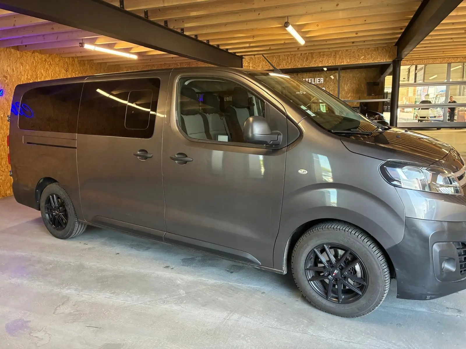 Vue latérale droite d'un Citroën Jumpy XL Spacetourer gris 2017 avec vitres teintées et jantes noires en intérieur.