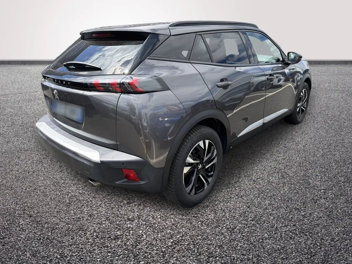 Peugeot 2008 gris foncé vue 3/4 arrière droit, avec feux arrière LED et jantes alliage bicolores.
