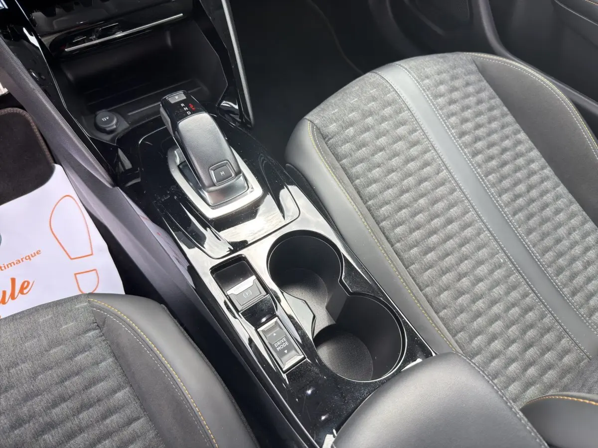 Vue rapprochée de la console centrale noire et des sièges gris avec surpiqûres jaunes du Peugeot 2008 2022.