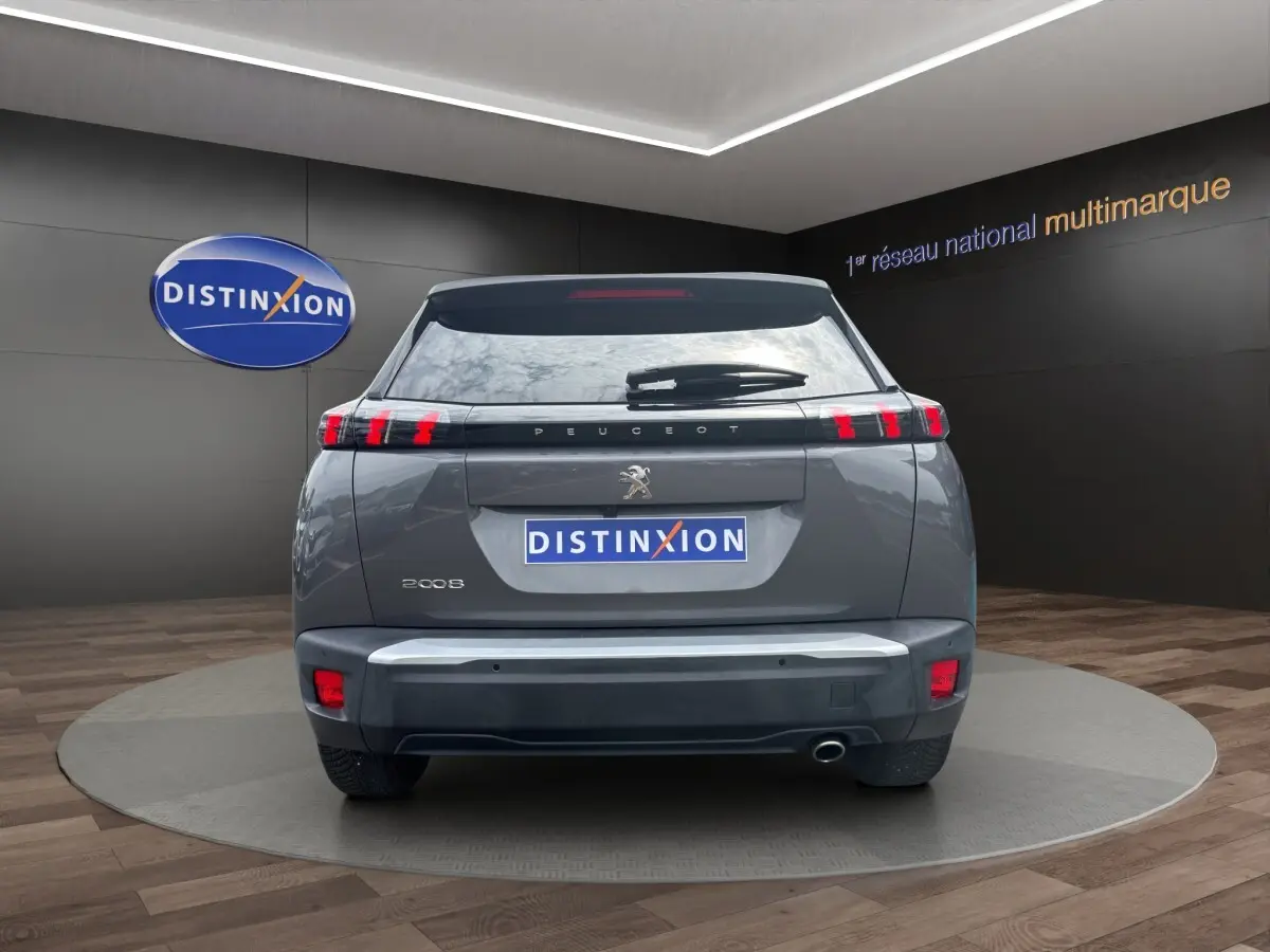 Vue arrière d'un Peugeot 2008 gris foncé 2022 avec feux LED caractéristiques et logo lion central visible.