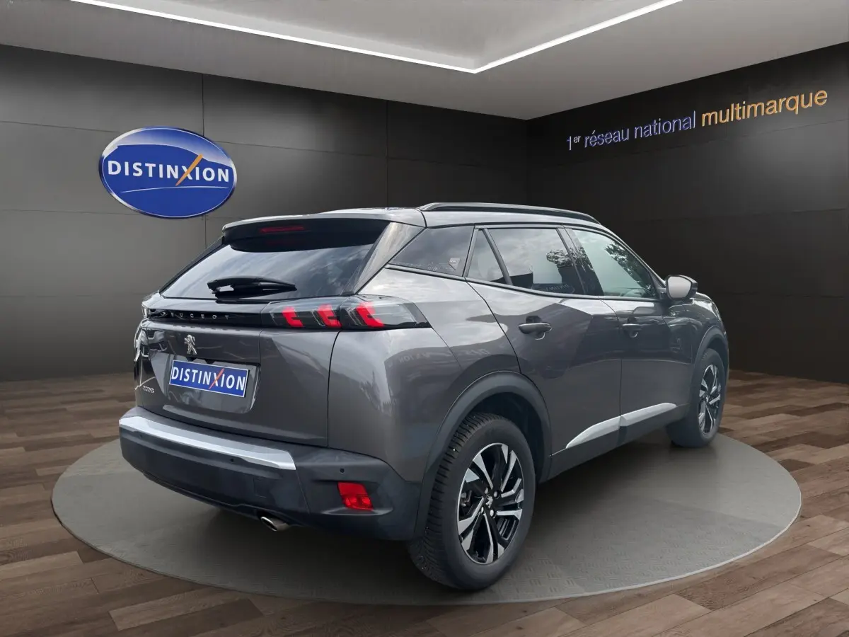 Peugeot 2008 gris foncé vue 3/4 arrière droit, avec feux LED et jantes alliage distinctives.